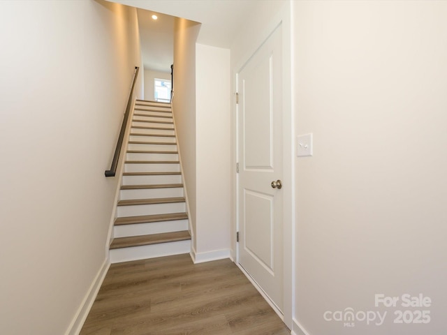 stairs with recessed lighting, wood finished floors, and baseboards