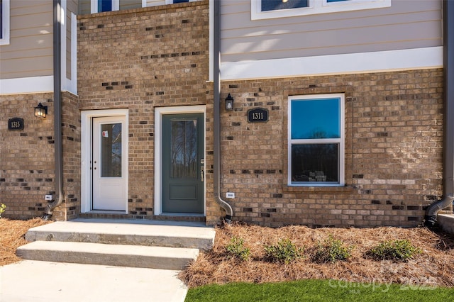 doorway to property with brick siding