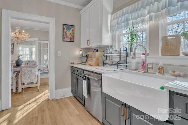 kitchen featuring white cabinetry, light hardwood / wood-style flooring, ornamental molding, dishwasher, and a notable chandelier