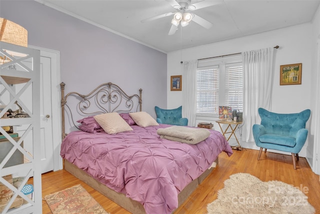 bedroom featuring hardwood / wood-style flooring, ceiling fan, and crown molding