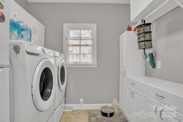 washroom with cabinets, washing machine and dryer, and light tile patterned floors