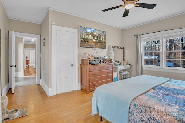 bedroom with ornamental molding, ceiling fan, and light hardwood / wood-style flooring