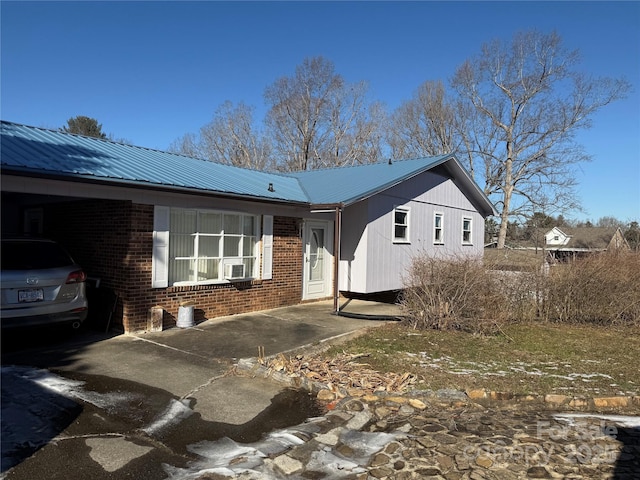 view of front of house featuring metal roof and brick siding