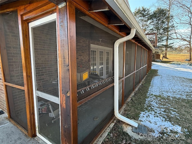 view of home's exterior with a sunroom and brick siding