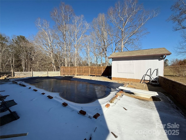 view of swimming pool with a fenced in pool, an outbuilding, fence, and a shed