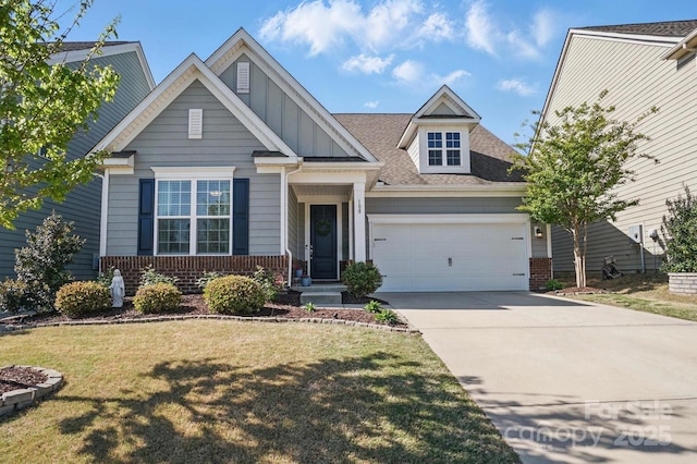 craftsman-style house with an attached garage, a front lawn, driveway, and brick siding