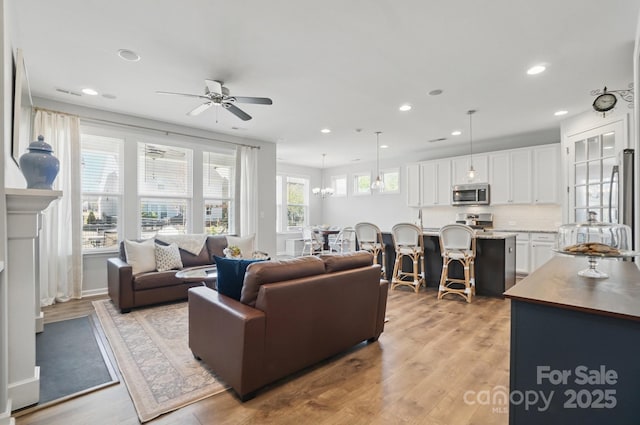 living area with recessed lighting, light wood-style floors, and ceiling fan
