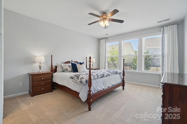 carpeted bedroom with visible vents, a ceiling fan, and baseboards