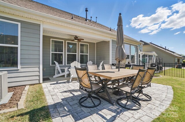 view of patio featuring fence, ceiling fan, outdoor dining area, and central air condition unit