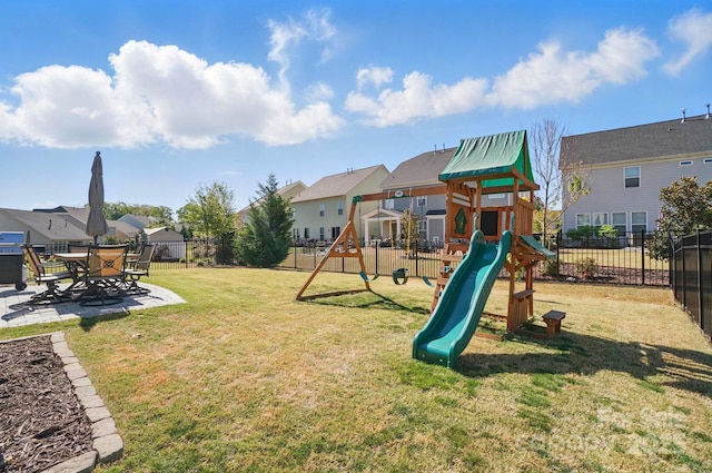 view of jungle gym featuring a fenced backyard, a yard, a residential view, and a patio