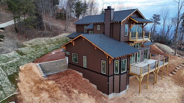 rear view of property featuring a wooden deck and a balcony