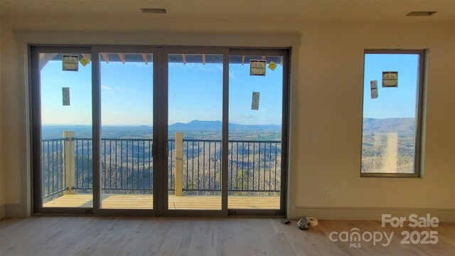 doorway with a mountain view and wood-type flooring