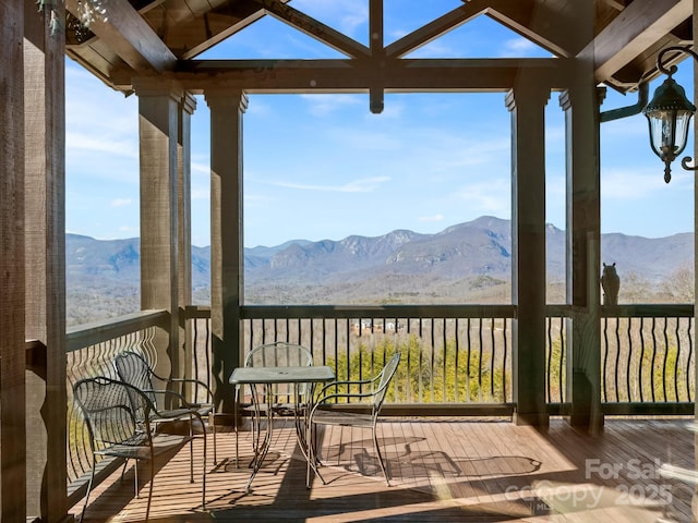 unfurnished sunroom with a mountain view and a healthy amount of sunlight