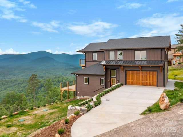 246 Half Moon Mile, Lake Lure, NC 28746 - view of front of home with a standing seam roof, a mountain view, concrete driveway, a garage, and board and batten siding