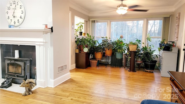 sunroom featuring ceiling fan and a wood stove