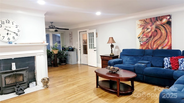 living room featuring ornamental molding, ceiling fan, and light hardwood / wood-style flooring