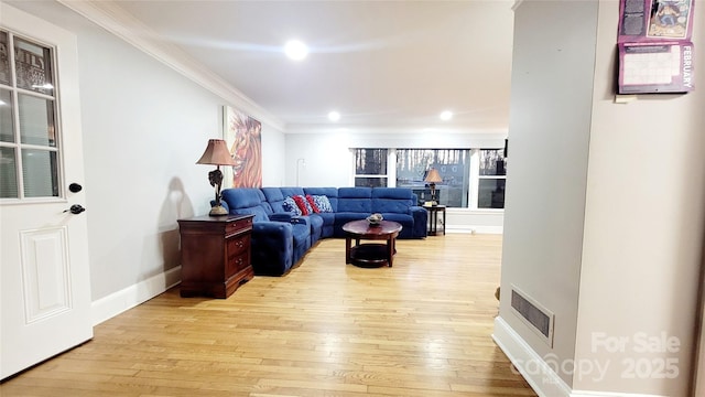 living room with ornamental molding and light wood-type flooring