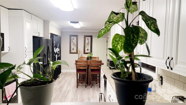 kitchen with white cabinetry, decorative backsplash, crown molding, fridge with ice dispenser, and light hardwood / wood-style flooring