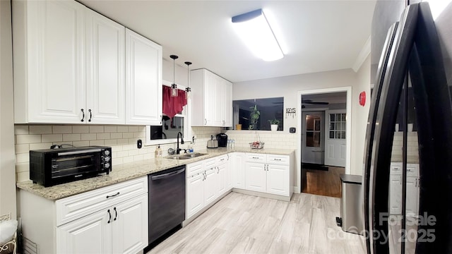 kitchen featuring sink, black appliances, hanging light fixtures, and white cabinets