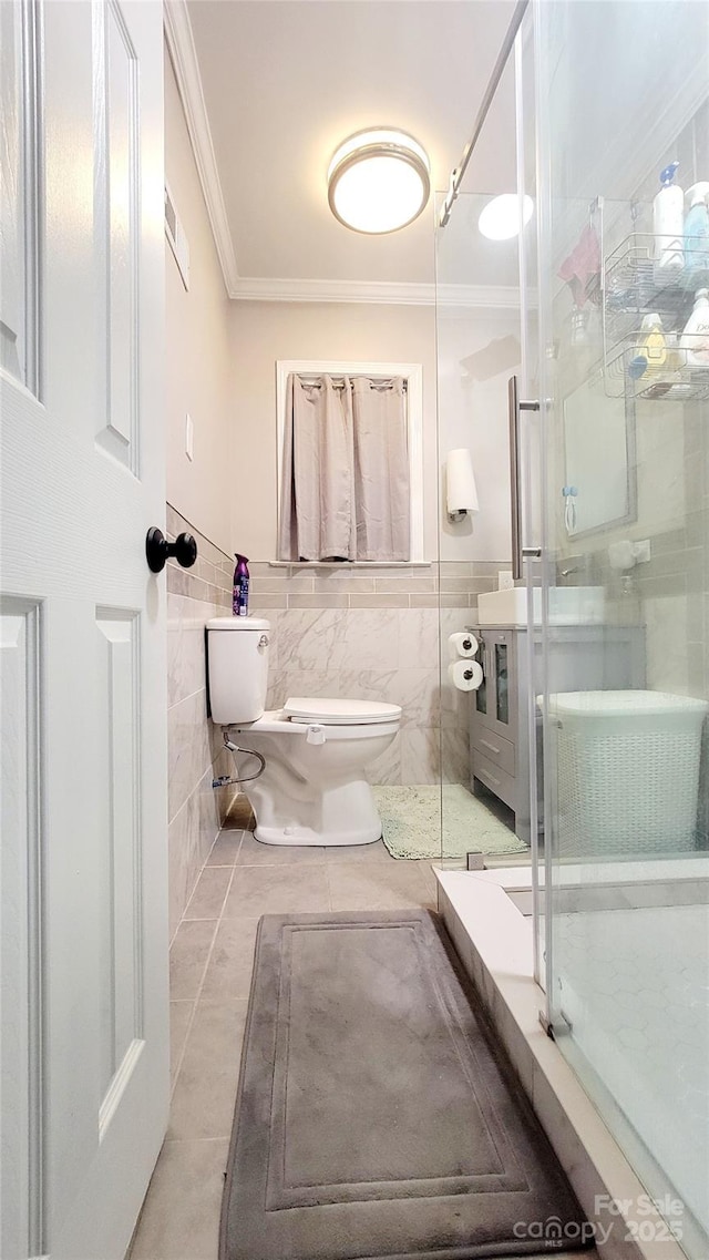 bathroom featuring crown molding, toilet, an enclosed shower, and tile walls