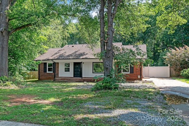 711 E John St, Matthews, NC 28105 - view of front of house with covered porch, brick siding, driveway, and a shingled roof