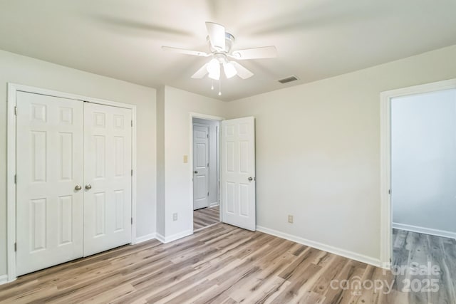 711 E John St, Matthews, NC 28105 - unfurnished bedroom with light wood-style flooring, a closet, and ceiling fan