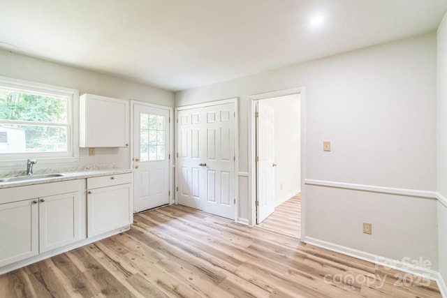 711 E John St, Matthews, NC 28105 - kitchen with light wood-style floors, white cabinets, and light countertops