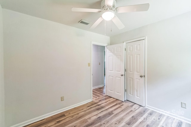 711 E John St, Matthews, NC 28105 - unfurnished bedroom with light wood-style flooring, ceiling fan, and a closet