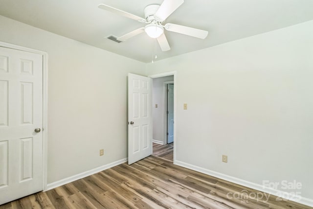 711 E John St, Matthews, NC 28105 - unfurnished bedroom with wood finished floors and a ceiling fan