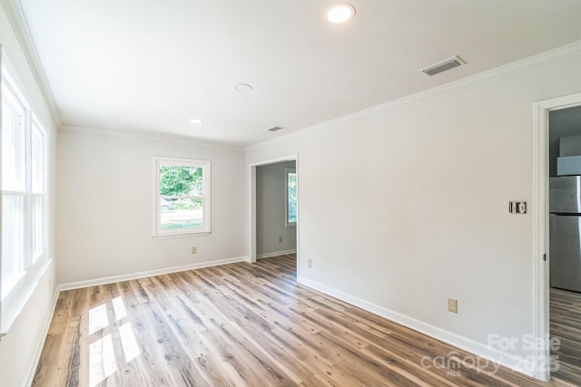 711 E John St, Matthews, NC 28105 - spare room featuring light wood-type flooring, crown molding, and recessed lighting