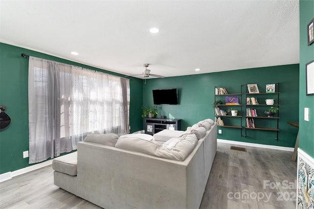 living room featuring ceiling fan and light hardwood / wood-style flooring