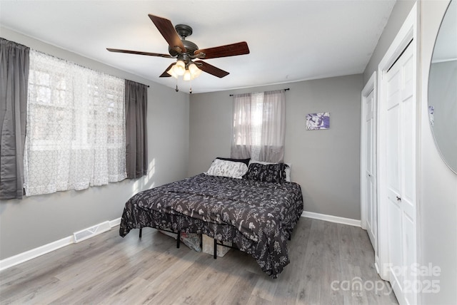 bedroom featuring ceiling fan, a closet, and light wood-type flooring