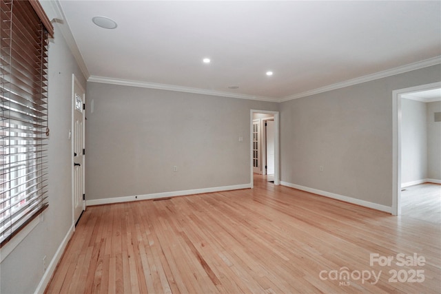 spare room featuring ornamental molding and light hardwood / wood-style flooring