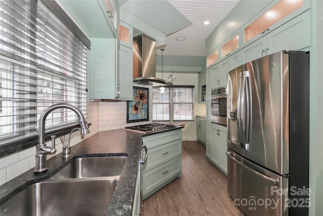 kitchen featuring sink, tasteful backsplash, hanging light fixtures, appliances with stainless steel finishes, and island exhaust hood