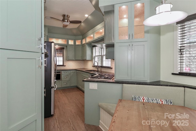 kitchen featuring sink, hardwood / wood-style flooring, hanging light fixtures, backsplash, and stainless steel appliances