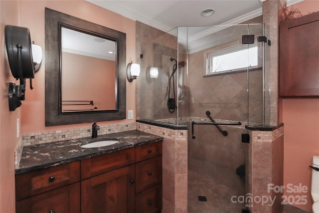 bathroom featuring tasteful backsplash, ornamental molding, vanity, and a shower with shower door