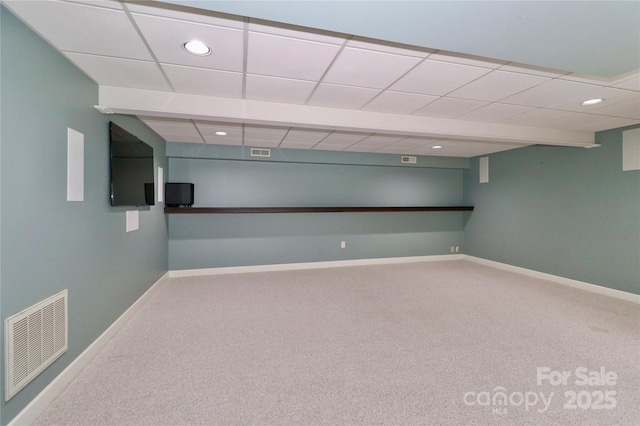 basement featuring carpet floors and a paneled ceiling