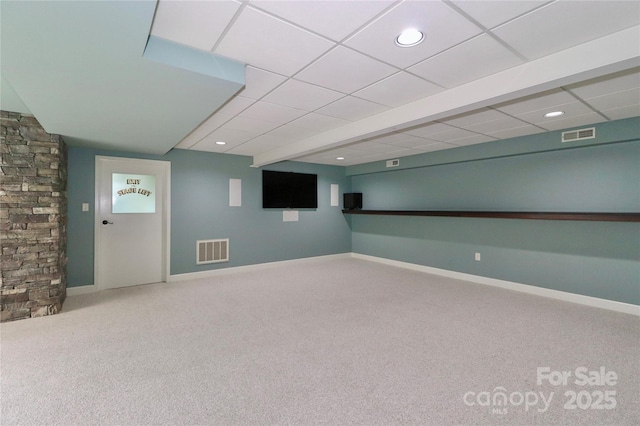 basement with a paneled ceiling and carpet