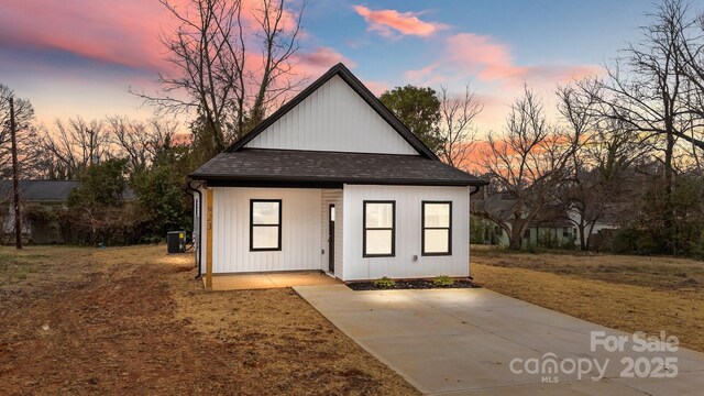 view of front of house featuring a yard and central AC