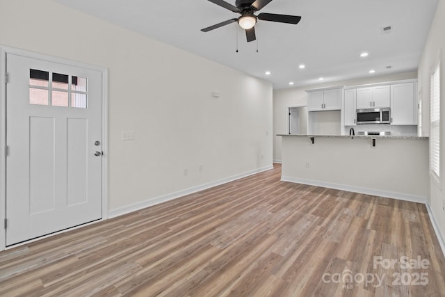 unfurnished living room with light hardwood / wood-style flooring and ceiling fan