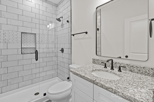 bathroom with an enclosed shower, vanity, and toilet