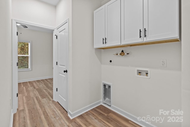 clothes washing area featuring cabinets, electric dryer hookup, washer hookup, and light wood-type flooring