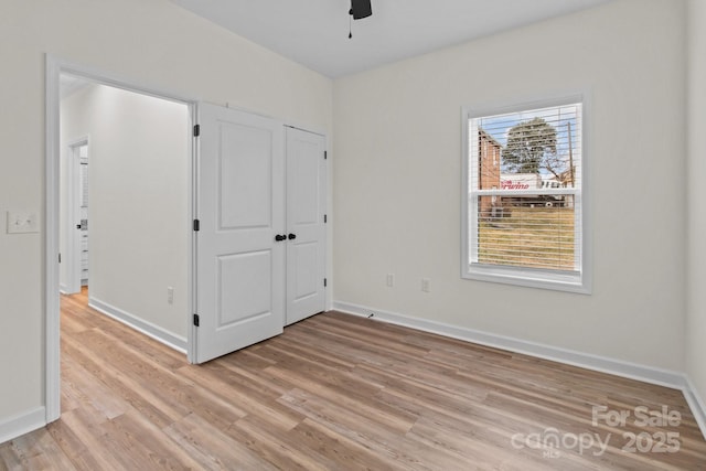 unfurnished bedroom with ceiling fan and light wood-type flooring