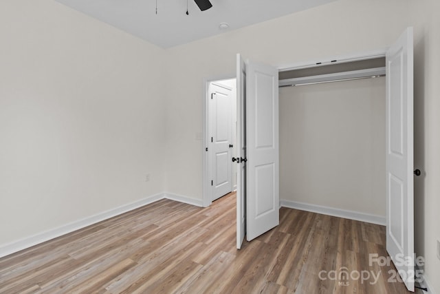 unfurnished bedroom with hardwood / wood-style floors, ceiling fan, and a closet