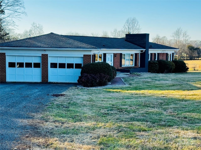 ranch-style home featuring a garage and a front yard