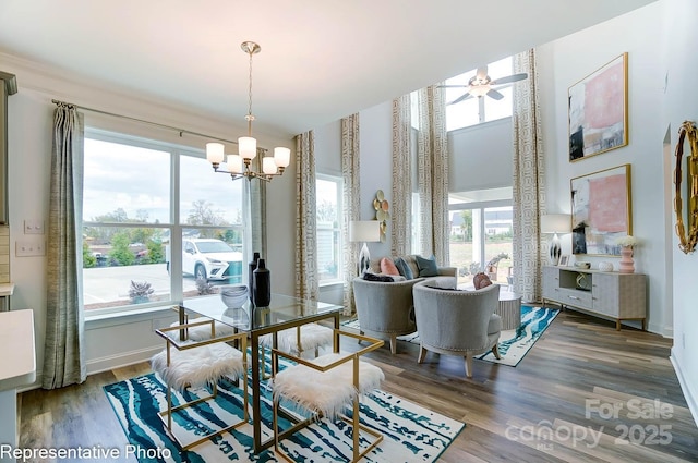 dining room featuring a wealth of natural light, wood-type flooring, and ceiling fan with notable chandelier