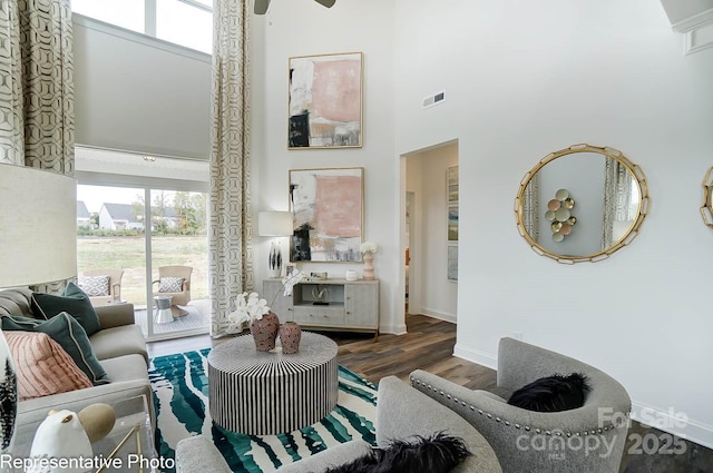 living room with dark hardwood / wood-style flooring and a high ceiling