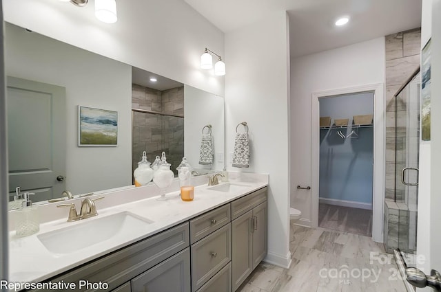 bathroom with vanity, toilet, and a shower with shower door