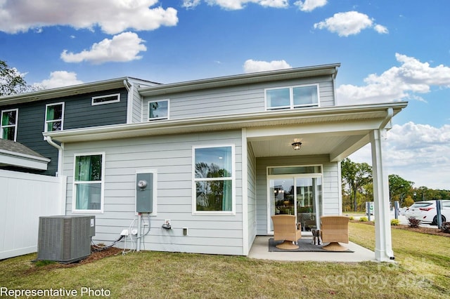 back of house featuring central AC unit, a yard, and a patio