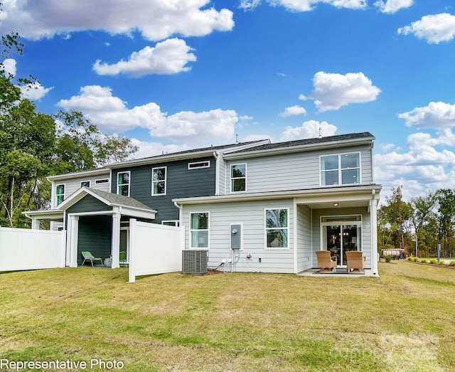 rear view of property with cooling unit, a yard, and a patio area